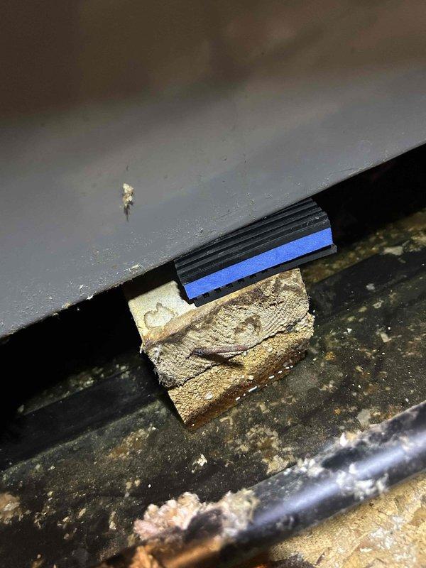 Responded to water leak complaint with HVAC system dripping through ceiling. Upon inspection, accessed unit and identified condensate drain line issue with excessive dust and debris accumulation throughout the mechanical compartment. Found PVC condensate drain line with visible valve and fittings showing signs of potential blockage or improper drainage. Documented heavily soiled conditions including thick dust buildup on flexible ductwork, refrigerant lines, and surrounding surfaces that may contribute to moisture-related problems. System currently maintaining heating and cooling functionality despite active leak. Photographed wooden shim installation between components and overall condition of confined mechanical space for records. Recommended thorough cleaning of drain line system and removal of accumulated debris to prevent future water intrusion issues.