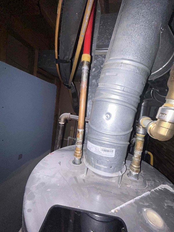 Completed comprehensive plumbing inspection of unpermitted basement bathroom installation to verify code compliance for real estate transaction. Examined all visible plumbing components including supply lines, drain waste vent system, pipe materials, connections, and installation methods throughout the mechanical space. Documented findings with photographic evidence showing copper supply piping, PVC drainage system, water heater connections, and HVAC integration within the confined utility area between floor joists and wall framing.