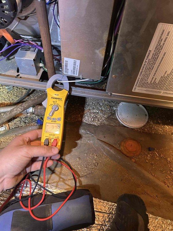 Completed preventative maintenance tune-up on residential air conditioning system with gas furnace located in crawlspace accessible through interior closet. Performed comprehensive system diagnostics using clamp meter to verify electrical readings and amperage draws on both indoor and outdoor units. Inspected outdoor condensing unit positioned on concrete pad against brick exterior, confirmed proper operation of compressor and condenser fan assembly, and verified electrical disconnect box connections. Noted that humidifier pad #35 will be supplied during fall maintenance visit as included in membership, and filters will be provided by homeowner.