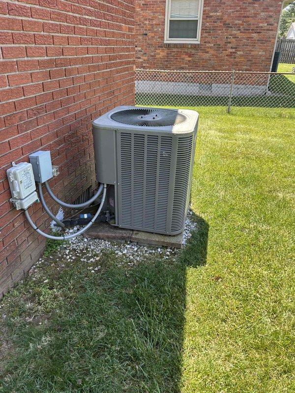 Completed preventative maintenance tune-up on residential air conditioning system with gas furnace located in crawlspace accessible through interior closet. Performed comprehensive system diagnostics using clamp meter to verify electrical readings and amperage draws on both indoor and outdoor units. Inspected outdoor condensing unit positioned on concrete pad against brick exterior, confirmed proper operation of compressor and condenser fan assembly, and verified electrical disconnect box connections. Noted that humidifier pad #35 will be supplied during fall maintenance visit as included in membership, and filters will be provided by homeowner.