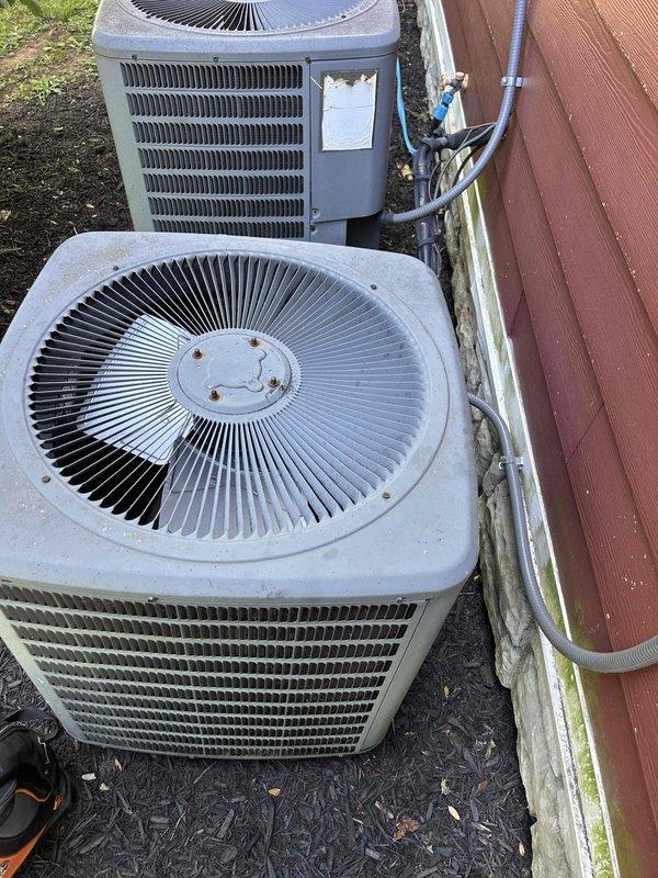 Responded to no cooling call for 20-year-old upstairs electric air conditioning system with R22 refrigerant that had been inoperative for two days. Indoor unit located in basement. Performed diagnostic evaluation of system including inspection of outdoor condenser units, electrical panel connections, and refrigerant lines. Documented existing dual-unit configuration with upstairs system experiencing failure while downstairs system remained operational. Assessed circuit breaker panel showing dedicated circuits for both AC units and confirmed electrical supply to affected system. Inspected outdoor condenser units showing age-related weathering and examined refrigerant line connections between units. System filter had been changed within recent months. Due to advanced age of equipment and R22 refrigerant type, discussed replacement options as requested for aging upstairs system.