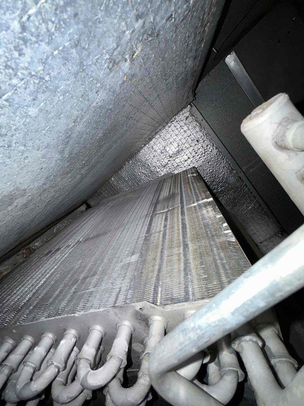 Completed comprehensive air conditioning maintenance and system diagnostics on basement-located gas furnace/AC combination unit as part of preventive care plan service. Performed thorough inspection of evaporator coil assembly, which showed acceptable cleanliness with minimal dust accumulation on fins and refrigerant lines. Utilized digital multimeter to verify electrical readings and system parameters, confirming proper voltage and operational specifications throughout the unit.