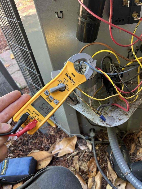 Completed Gold Level prepaid maintenance on two 9-year-old AC systems in a dual-zone residential property with units located in basement and second-floor closet. Performed comprehensive system diagnostics including electrical testing with clamp meter, which recorded 52.9 amp draw on outdoor condenser unit. Inspected capacitor, wiring connections, and electrical components for proper operation and signs of wear. Noted significant debris accumulation including dried leaves inside outdoor unit cabinet and excessive vegetation growth obstructing airflow around exterior condenser unit against brick wall. Cleaned accessible components and documented conditions requiring attention. Verified both systems operational. Customer providing their own filters for routine replacement.