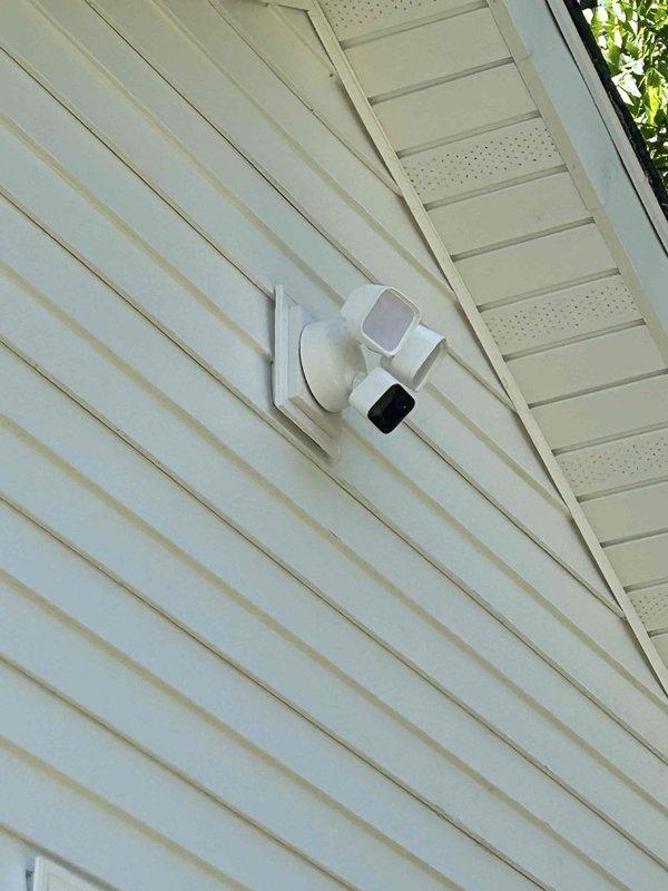 Completed final phase of electrical rewire installation including mounting of all devices, fixtures, and cover plates throughout the property. Installed exterior electrical meter enclosure on building exterior wall and mounted dual-head security lighting fixture under soffit overhang with proper weatherproof connections. All work completed to code specifications and prepared for final electrical inspection.