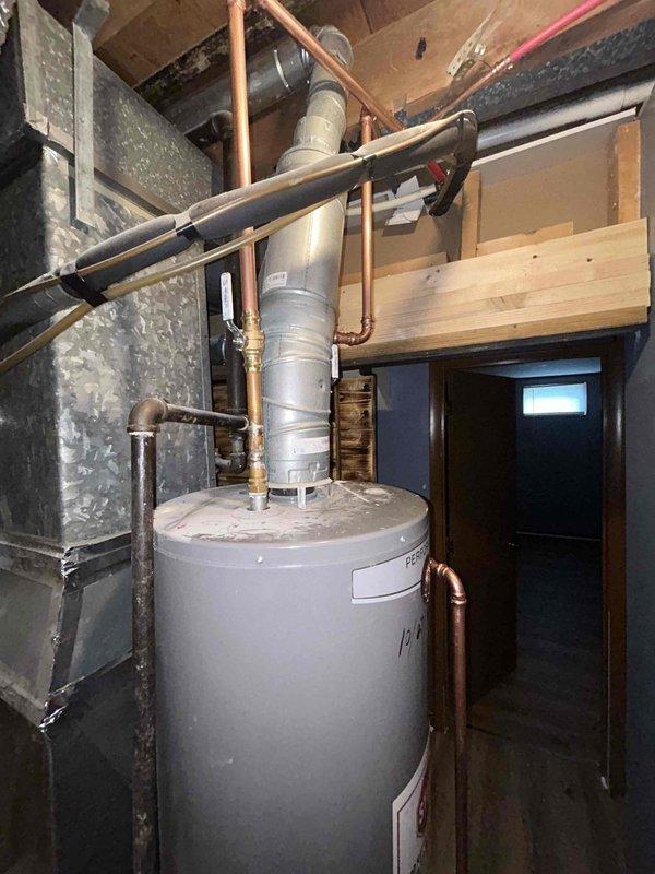 Completed rebuild of drain assembly under kitchen sink to restore proper drainage function. Performed small section repipe above water heater, relocating PEX water lines away from exhaust flue to ensure safe clearance and compliance with code requirements. Work included installing new drain piping, fittings, and repositioning supply lines to eliminate potential heat exposure hazard from water heater exhaust vent.