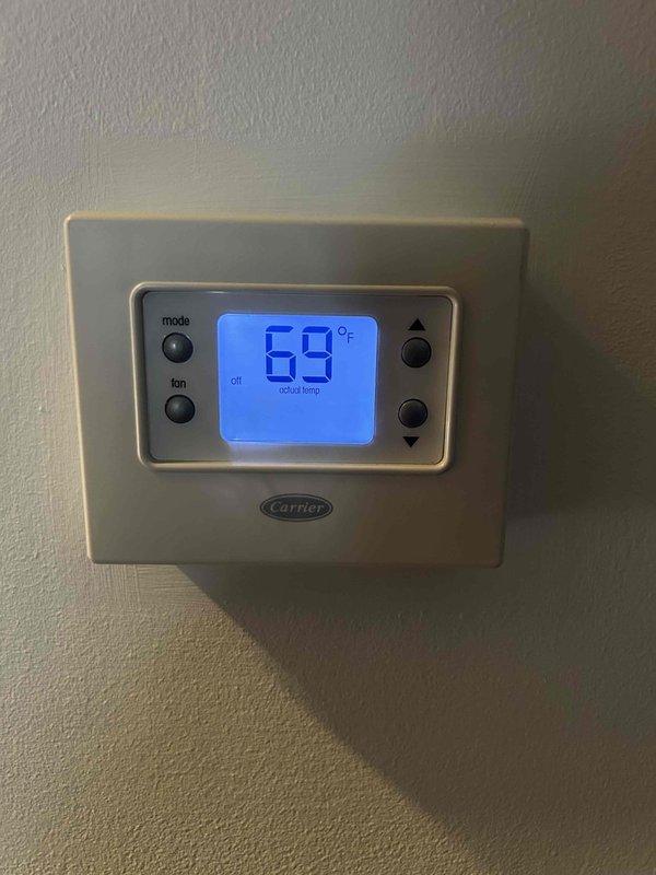 Completed annual care plan maintenance tune-up on Carrier heat pump system with air handler located in basement. Performed comprehensive inspection of indoor and outdoor equipment, verified thermostat operation showing 69°F actual temperature, inspected Mitsubishi Electric outdoor unit with dual fan configuration, checked electrical connections, tested system controls, and confirmed proper operation of all components. Customer provides their own 20x25x4 filter for routine replacement.
