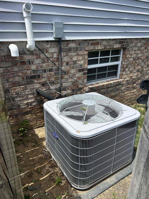 Responded to no cooling complaint on 10-12 year old gas furnace/AC system with continuous fan operation. Upon arrival, found thermostat displaying "cool set at 75" with system calling for cooling. Performed diagnostic evaluation of outdoor condensing unit and indoor air handler located in basement with easy access. Inspected white condenser unit positioned on concrete pad against exterior brick wall, verified proper power supply from electrical junction box, and checked refrigerant lines and condensate drain routing through PVC piping. Examined programmable thermostat controls and verified settings, noting "check hum pad" and "check filter" indicators on display. Tested system operation including compressor engagement, fan cycling, and airflow delivery. Filter had been changed during previous maintenance visit. Identified root cause of continuous fan operation and inadequate cooling performance, distinguishing from previous maintenance inspection findings. Completed necessary repairs t