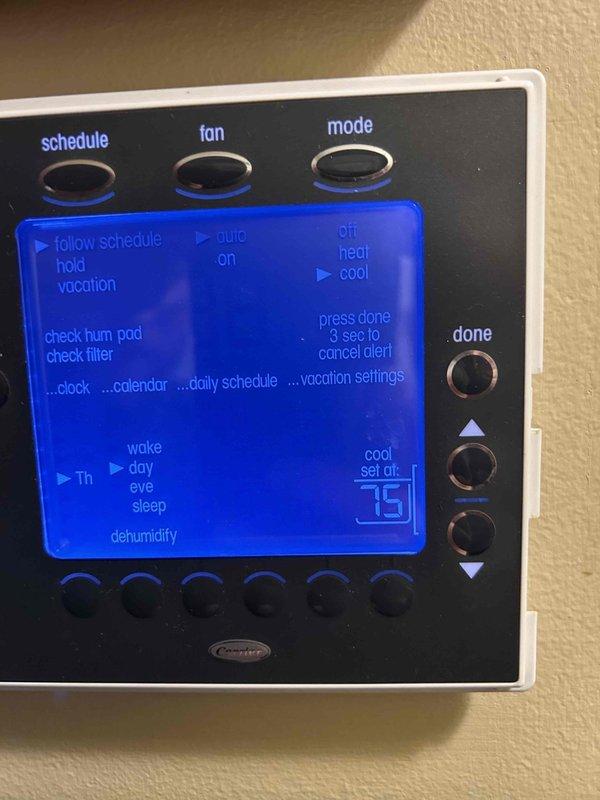 Responded to no cooling complaint on 10-12 year old gas furnace/AC system with continuous fan operation. Upon arrival, found thermostat displaying "cool set at 75" with system calling for cooling. Performed diagnostic evaluation of outdoor condensing unit and indoor air handler located in basement with easy access. Inspected white condenser unit positioned on concrete pad against exterior brick wall, verified proper power supply from electrical junction box, and checked refrigerant lines and condensate drain routing through PVC piping. Examined programmable thermostat controls and verified settings, noting "check hum pad" and "check filter" indicators on display. Tested system operation including compressor engagement, fan cycling, and airflow delivery. Filter had been changed during previous maintenance visit. Identified root cause of continuous fan operation and inadequate cooling performance, distinguishing from previous maintenance inspection findings. Completed necessary repairs t