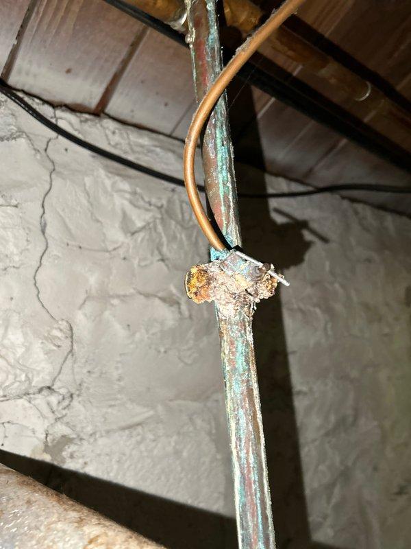 # Plumbing Inspection Summary

Completed comprehensive plumbing inspection as part of routine preventive maintenance service agreement. Inspected residential plumbing fixtures and infrastructure throughout the property, including bathroom facilities and basement utility areas.

## Findings and Observations

**Bathroom Fixtures:**
Inspected bathroom sink, faucet assembly, and drainage system. Two-handle chrome faucet with central spout operating properly with adequate water flow and pressure. Drain stopper functioning correctly with no visible leaks at basin connections. Fixture mounting secure and countertop area showing normal wear consistent with age. No immediate repairs required for bathroom plumbing fixtures.

**Basement Plumbing Infrastructure:**
Identified significant corrosion on vertical copper supply line at joint connection point in basement utility area. Corrosion presents as blue-green verdigris with crusty buildup and white deposits concentrated around cross-fitting conne