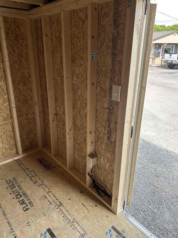 Completed electrical rough-in and installation for a newly constructed wood-framed outbuilding. Installed GFCI receptacle, standard duplex receptacle, single-pole switch, keyless light fixture with bulb, and SJ cord with male cord cap per specifications. All wiring routed through wall studs and properly secured, with electrical boxes mounted to framing members in accordance with code requirements.