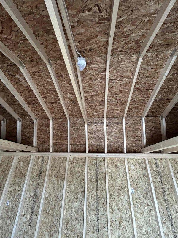 Completed electrical rough-in and installation for a newly constructed wood-framed outbuilding. Installed GFCI receptacle, standard duplex receptacle, single-pole switch, keyless light fixture with bulb, and SJ cord with male cord cap per specifications. All wiring routed through wall studs and properly secured, with electrical boxes mounted to framing members in accordance with code requirements.