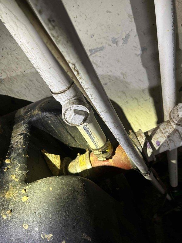 Responded to commercial urinal clog complaint and performed diagnostic inspection of plumbing system. Upon investigation, discovered the issue extended beyond the urinal to include failed baffles in the grease trap pump system. Assessed damaged inlet and outlet baffles that had broken and deteriorated, compromising the grease trap's functionality. Documented existing conditions including discolored water and corroded plumbing components showing significant wear and deterioration. Provided assessment for necessary repairs to restore proper operation of both the urinal drainage system and grease trap pump assembly.