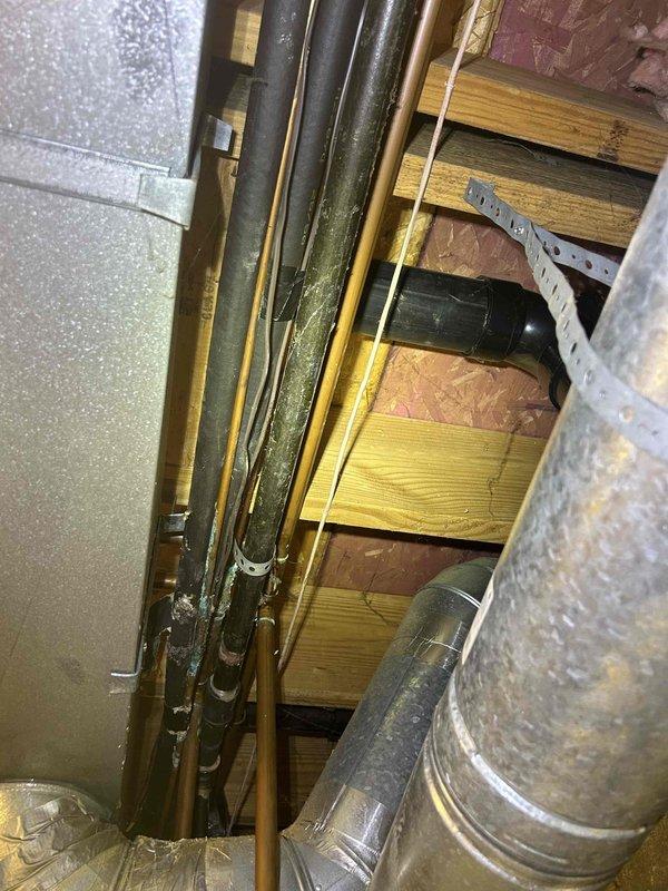 Responded to non-urgent service call to assess HVAC line interference with plumbing repair work. Upon inspection of attic space, documented existing refrigerant line set routing that requires relocation to allow plumbing contractor access for water line leak repair. Photographed current piping configuration showing copper refrigerant lines, support brackets, and proximity to affected plumbing area. Noted significant frost accumulation on copper refrigerant line indicating active system operation and proper refrigerant flow. Documented spatial constraints including wooden structural beams, existing ductwork, and insulation that will impact line set relocation. Prepared documentation and photographs for quote preparation to relocate refrigerant line set, which will require system pump-down, line disconnection, rerouting, reconnection, pressure testing, evacuation, and refrigerant recharge upon completion.
