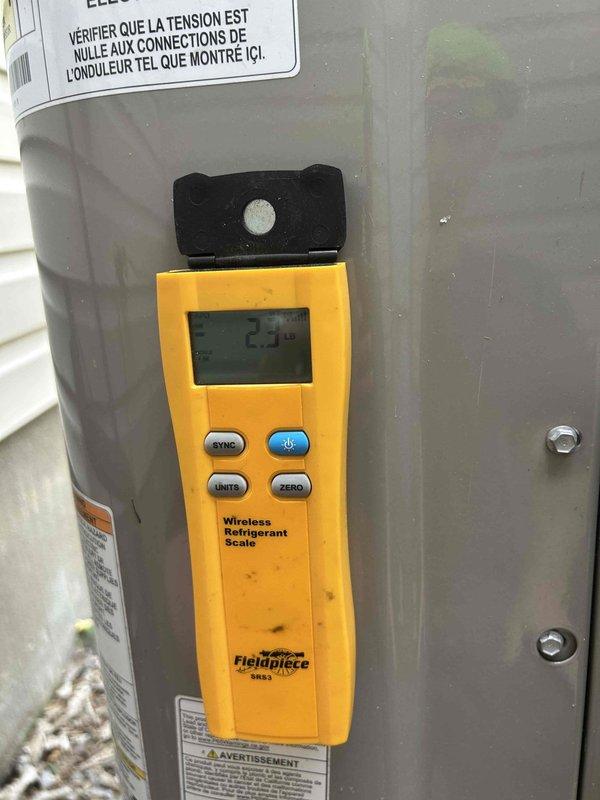 Responded to callback for ongoing water leak issue. Performed comprehensive system diagnostics using refrigerant manifold and micron gauge to check pressures and temperatures across all zones. Connected service hoses to condensing unit valve ports to verify refrigerant charge levels and rule out evaporator coil freeze-up as potential leak source. Measured refrigerant weight at 2.3 lbs using wireless scale on tank to confirm proper charge. Inspected all visible refrigerant lines, condensate drain system, and connections at outdoor unit. Unable to locate source of water leak during this visit. Recommend continued monitoring and possible camera inspection of drain lines or further investigation of indoor air handler components on next service call.