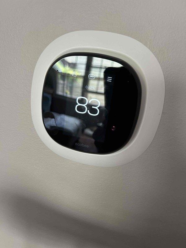 Responded to no cooling complaint on 20-year-old electric air conditioning system with indoor unit located in utility closet. Upon arrival, thermostat displayed 83°F with setpoint at 70°F. Confirmed airflow from supply registers but no temperature reduction. Performed diagnostic evaluation of indoor air handler and measured supply air temperature at 25.4°F temperature split, indicating insufficient cooling capacity. System blowing air but failing to adequately condition space due to age-related component degradation on unit operating two decades beyond typical service life.