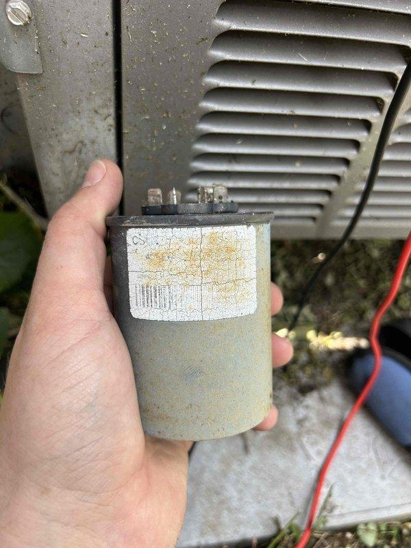 Responded to no cooling complaint on 12-year-old electric HVAC system where outdoor unit was humming but condenser fan would not engage. Upon inspection, diagnosed failed run capacitor on outdoor condensing unit. Capacitor exhibited significant age-related deterioration including corrosion, discoloration, and loss of capacitance. Replaced defective run capacitor with new component matching manufacturer specifications. Verified proper fan motor operation, checked amperage draws on compressor and fan motor, and confirmed system returned to normal cooling operation. Also inspected attic-mounted air handler unit and noted frost accumulation on exterior surfaces indicating possible airflow restriction or refrigerant issue that may require future attention if cooling performance does not normalize after capacitor replacement.