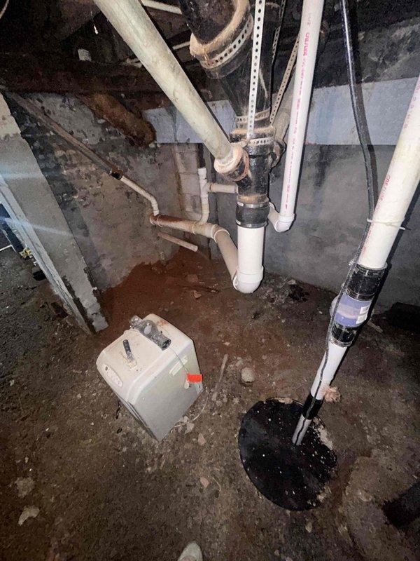 Conducted on-site plumbing estimate for water heater replacement in basement location. Assessed existing 50-gallon conventional tank water heater (Smith ProMax model) for conversion to tankless system. Evaluated current installation conditions including concrete block wall structure, existing plumbing connections, venting requirements, and electrical/gas utility access. Documented basement moisture conditions and floor staining that may require remediation consideration. Photographed existing water heater setup, surrounding piping infrastructure including copper and PVC lines, and available clearance space for potential tankless unit installation. Reviewed structural support requirements and determined necessary modifications for transitioning from tank to tankless configuration.