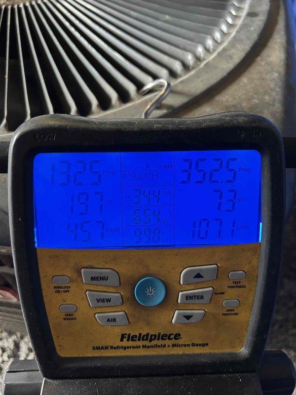 Responded to commercial no cooling call on 11-15 year old electric system with front unit located in breezeway. Upon arrival, confirmed system was running but not providing adequate cooling. Performed diagnostic evaluation using refrigerant manifold and micron gauge to assess system pressures and refrigerant levels. Testing revealed low refrigerant charge at 45 ounces measured on wireless refrigerant scale, indicating system was operating below manufacturer specifications. Recharged system to proper levels and verified pressures returned to normal operating range. System restored to full cooling capacity and left operational.