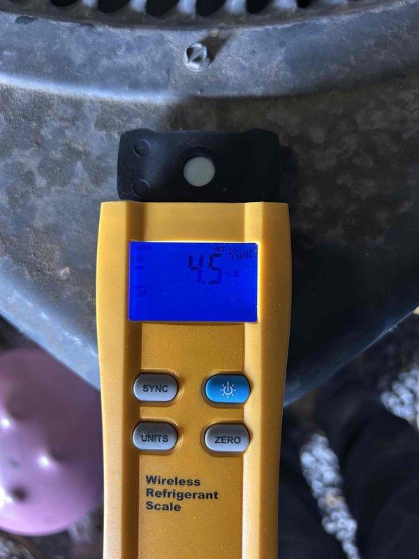 Responded to commercial no cooling call on 11-15 year old electric system with front unit located in breezeway. Upon arrival, confirmed system was running but not providing adequate cooling. Performed diagnostic evaluation using refrigerant manifold and micron gauge to assess system pressures and refrigerant levels. Testing revealed low refrigerant charge at 45 ounces measured on wireless refrigerant scale, indicating system was operating below manufacturer specifications. Recharged system to proper levels and verified pressures returned to normal operating range. System restored to full cooling capacity and left operational.