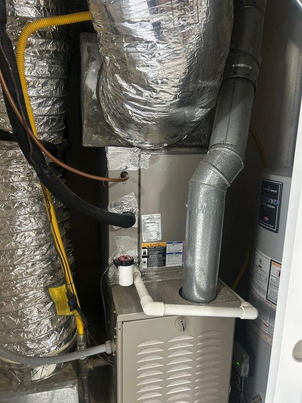 Completed comprehensive AC tune-up on Carrier air conditioning and gas furnace system located in garage utility closet. Performed routine maintenance inspection including checking refrigerant levels, cleaning condenser coils, inspecting electrical connections, testing thermostat operation, verifying proper condensate drain function through PVC drainage system, and examining flex ductwork connections for secure sealing. System operational and running efficiently with no issues identified during service visit.