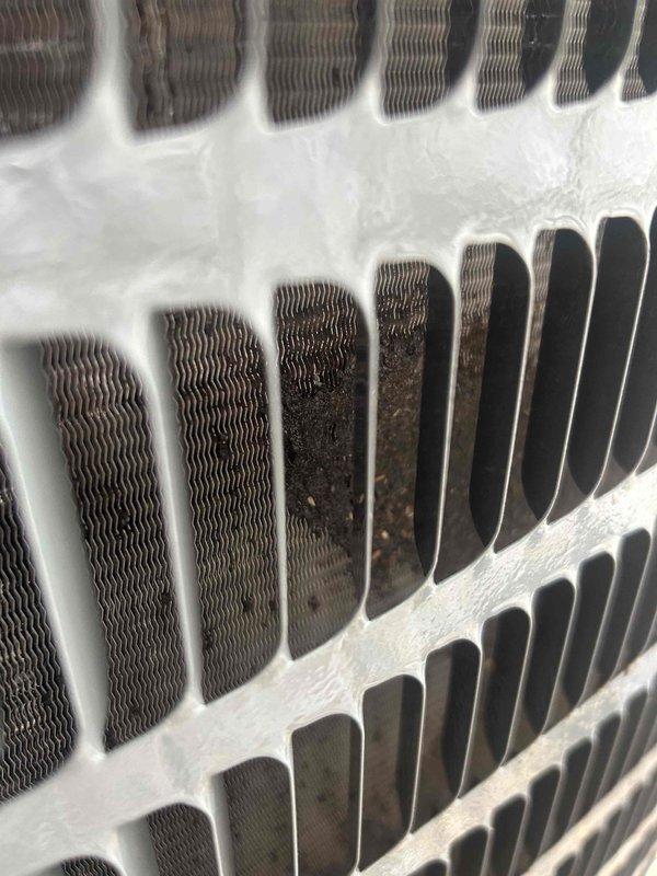 Responded to no cooling complaint on residential air conditioning system. Upon inspection, found evaporator coil completely frozen with heavy ice buildup and indoor coil fins severely clogged with dust and debris accumulation. Identified restricted airflow as primary cause due to lack of maintenance and dirty coil conditions. Shut down system to allow ice to thaw completely. Performed thorough coil cleaning to remove accumulated dirt and debris from evaporator fins. Verified proper refrigerant levels and system pressures after thaw cycle completed. Checked blower motor operation and airflow. System restored to normal cooling operation with improved airflow and heat transfer efficiency. Recommended regular filter changes and preventive maintenance to prevent future freeze-ups.