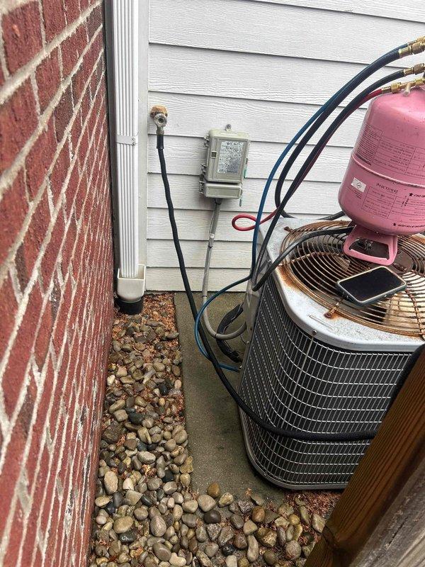 Performed comprehensive HVAC system replacement at residential property. Removed existing air conditioning unit and installed new cylindrical condenser unit on concrete pad adjacent to house exterior. Connected refrigerant lines with proper fittings, installed electrical disconnect box on exterior wall, and ran necessary conduit for power supply. Charged system with refrigerant, verified proper pressures using manifold gauges, and tested all electrical connections. System operational and running within manufacturer specifications upon completion.