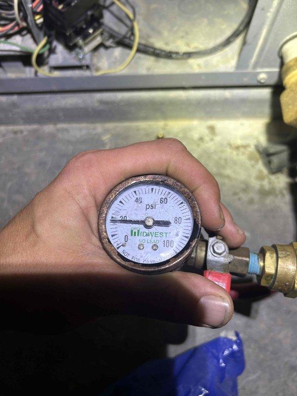 Responded to service call for 7-year-old geothermal system with reported annual refrigerant loss. Performed diagnostic pressure testing using analog gauges to assess system pressures and identify potential leak points in the refrigerant circuit. Customer reported uncertainty whether leak involved refrigerant or water loop, though system currently operating without performance degradation; further leak detection and monitoring recommended to determine source and prevent future recharge requirements.