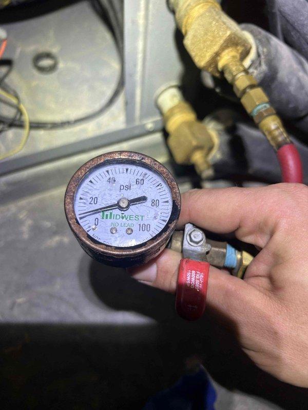Responded to service call for 7-year-old geothermal system with reported annual refrigerant loss. Performed diagnostic pressure testing using analog gauges to assess system pressures and identify potential leak points in the refrigerant circuit. Customer reported uncertainty whether leak involved refrigerant or water loop, though system currently operating without performance degradation; further leak detection and monitoring recommended to determine source and prevent future recharge requirements.