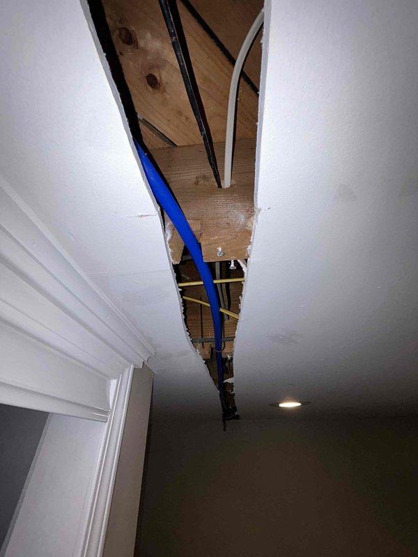 Accessed ceiling cavity to remove and replace deteriorated galvanized water supply line. Cut opening in drywall ceiling to expose existing pipe run and structural framing. Removed old galvanized piping and installed new PEX water line through ceiling space, securing properly to structural members. Installed new hose bibb at designated location and pressure tested system to verify proper operation and confirm no leaks. All connections made to code specifications with appropriate fittings and support.