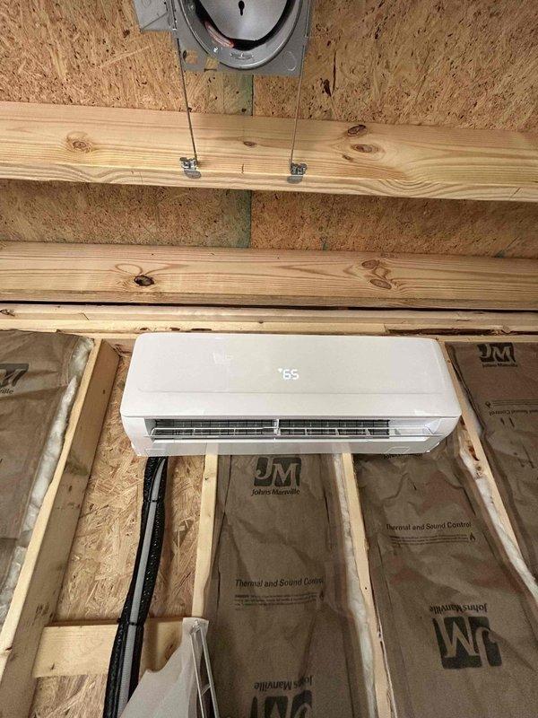 Returned to property to replace damaged bottom panel on ductless mini-split unit that was compromised during initial installation at auxiliary building beside main driveway. Retrieved replacement panel and remote control from warehouse staging area, installed new panel on wall-mounted indoor unit, and performed complete system startup and operational checkout to verify proper functionality.