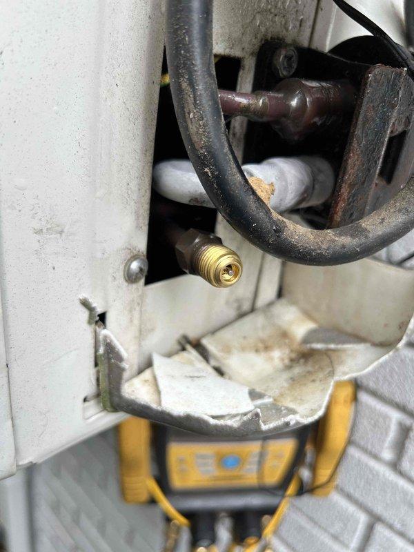 Responded to callback for mini-split system experiencing persistent water leakage following recent maintenance visit. Upon inspection, discovered severe corrosion and deterioration on refrigerant line connections and fittings near the indoor unit. The corroded piping showed extensive rust, pitting, and surface degradation, with compromised insulation indicating prolonged moisture exposure. Documented the damaged components and active leak points causing water infiltration into the drywall and hardwood flooring below.