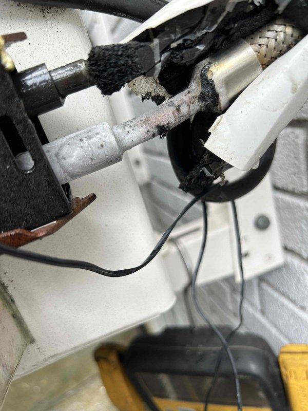 Responded to callback for mini-split system experiencing persistent water leakage following recent maintenance visit. Upon inspection, discovered severe corrosion and deterioration on refrigerant line connections and fittings near the indoor unit. The corroded piping showed extensive rust, pitting, and surface degradation, with compromised insulation indicating prolonged moisture exposure. Documented the damaged components and active leak points causing water infiltration into the drywall and hardwood flooring below.