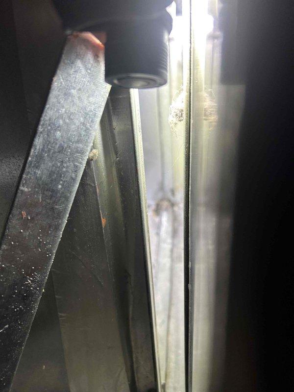 Responded to service call for non-operational whole-home dehumidifier integrated with HVAC system. Upon arrival, confirmed heating and cooling functions were operating normally while dehumidification system was inactive. Performed diagnostic inspection of dehumidifier unit and associated ductwork connections. Accessed equipment compartment and examined internal components, including duct connections, electrical connections, and drainage pathways. Inspected metal ductwork and air handler integration points for proper installation and potential obstruction issues. Noted moisture-related discoloration on vertical channels and accumulated debris in equipment base, suggesting previous condensate management concerns. Photographed equipment condition and configuration for service documentation. Equipment is approximately three years old and requires further evaluation to determine root cause of dehumidifier failure and recommend appropriate repair or replacement options.