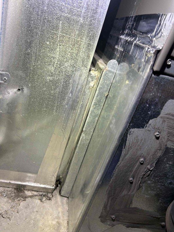 Responded to service call for non-operational whole-home dehumidifier integrated with HVAC system. Upon arrival, confirmed heating and cooling functions were operating normally while dehumidification system was inactive. Performed diagnostic inspection of dehumidifier unit and associated ductwork connections. Accessed equipment compartment and examined internal components, including duct connections, electrical connections, and drainage pathways. Inspected metal ductwork and air handler integration points for proper installation and potential obstruction issues. Noted moisture-related discoloration on vertical channels and accumulated debris in equipment base, suggesting previous condensate management concerns. Photographed equipment condition and configuration for service documentation. Equipment is approximately three years old and requires further evaluation to determine root cause of dehumidifier failure and recommend appropriate repair or replacement options.