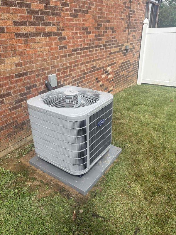 Completed full residential HVAC system replacement including installation of Carrier 3-ton 16.2 SEER2 Performance Series single-stage heat pump (model 27SPA636A003) on concrete pad with snow legs and electrical disconnect box in backyard against brick exterior wall. Installed Carrier 3-ton air handler with variable speed blower (model FT5ANXC36L00) in basement utility area with 15kW electric heat kit (model AFAEHL15B01A) and Carrier thermostat control. Added Aprilaire media cabinet air filtration system and condensate pump for proper drainage management. Ran insulated refrigerant lines with inline filter connecting outdoor condenser to indoor air handler, installed electrical whip kit and disconnect box for code compliance. Integrated SS2 coil drain safety water sensor with trap, fabricated transitions to existing ductwork system, and removed/disposed of old equipment. Pulled all applicable permits, tested system operation including heating and cooling modes, verified proper airflow an