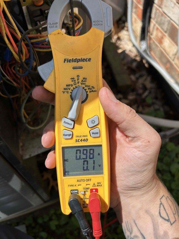 Completed comprehensive care plan tune-up on heat pump system. Performed electrical diagnostics using clamp meter, measuring amperage draw at 0.98A and voltage at 0.1V to verify proper system operation and component performance. Inspected condenser coil fins, control wiring connections, and all electrical components to ensure optimal heat pump functionality and efficiency.
