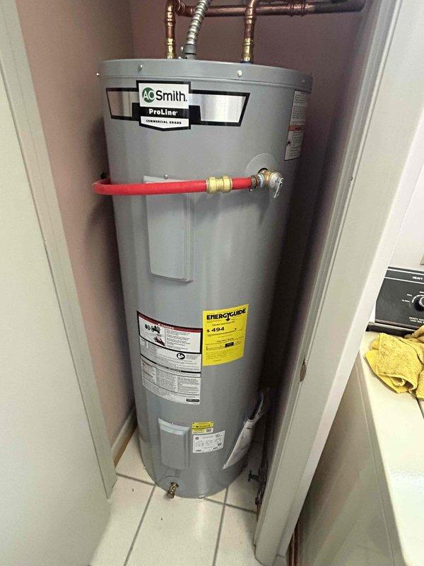 Responded to service call for no hot water condition on 8-year-old A.O. Smith ProLine tanked water heater located in residential utility closet. Upon arrival, performed comprehensive diagnostic evaluation of unit including inspection of gas supply line, pilot light assembly, thermocouple, gas control valve, and electrical connections. Verified proper gas flow through flexible metallic supply line and confirmed all plumbing connections at top of tank were secure with no visible leaks. Assessed copper piping configuration, brass fittings, and water line connections including the recirculation system components. Documented current condition of unit with detailed photographic records showing manufacturer labels, energy guide specifications, and overall installation setup. Unit appeared properly installed with adequate clearances and ventilation in confined space.
