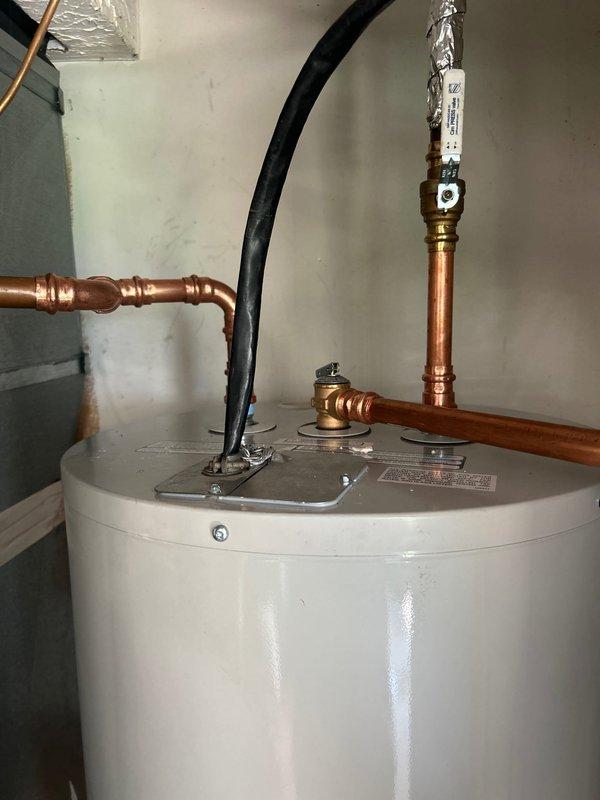 Completed installation of a 50-gallon water heater with new copper supply line connections and shutoff valves. All plumbing connections were properly fitted and secured, including T-fittings and brass components, with appropriate insulation applied to hot water lines to ensure efficient operation and code compliance.