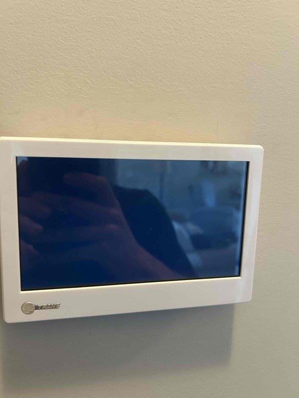Responded to callback for non-functioning thermostat on system installed 8 months prior. Upon arrival, confirmed thermostat had backlight power but displayed no information and was unresponsive to inputs, leaving HVAC system inoperable. Performed diagnostic testing using digital multimeter to verify 24VAC power supply to thermostat terminals. Determined thermostat had internal component failure preventing proper display and communication with system. Replaced defective thermostat with new unit, verified proper wiring connections at R, C, W, Y, and G terminals, and restored power to system. Confirmed new thermostat powered on correctly with full display functionality and responsive touch controls. Cycled system through heating and cooling modes to verify proper communication between thermostat and equipment. System now operating normally with full thermostat control restored.