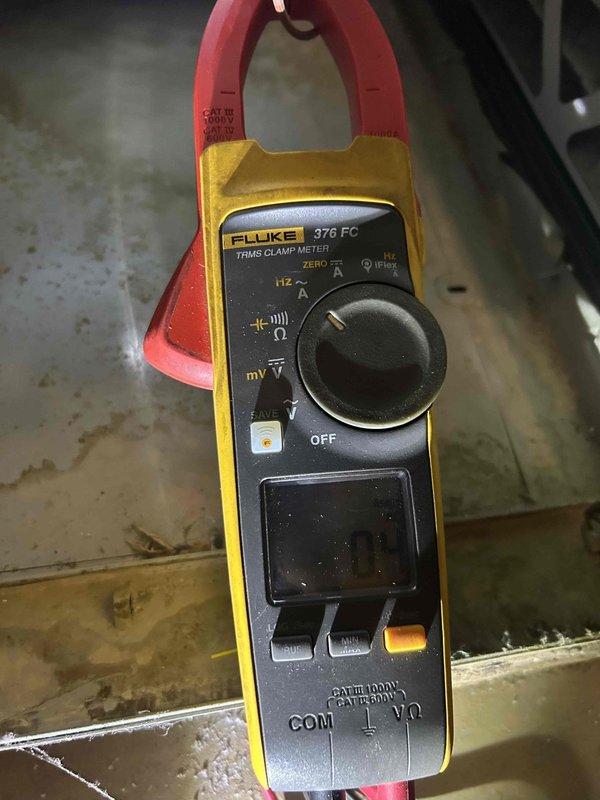 Responded to no cooling complaint on 6-year-old gas furnace/AC system with outdoor unit not running and indoor unit blowing ambient temperature air. Upon arrival, performed diagnostic evaluation of the system including electrical testing of the outdoor condensing unit. Used clamp meter to verify power supply and measure electrical parameters at the condenser. Inspected Trane XE60 gas furnace and associated ductwork for proper operation and airflow. Identified issue preventing outdoor unit operation and documented equipment conditions with diagnostic photos for service records.