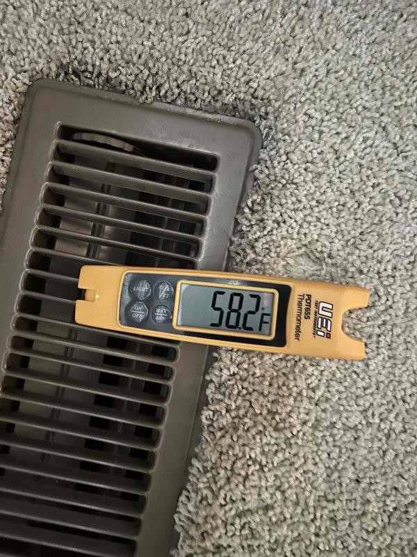 Responded to no cooling complaint on 15-20 year old dual fuel system blowing room temperature air. Upon arrival, performed diagnostic testing and confirmed supply air temperature at register measuring 58.2°F, indicating lack of cooling capacity. Utilized clamp meter to measure electrical current draw at outdoor unit, recording 0.52 amps, which is significantly below normal operating amperage for compressor operation. Low amperage reading suggests compressor failure, loss of refrigerant charge, or failed start components preventing compressor from running. Documented findings with thermal and electrical measurements for customer review and repair recommendations.