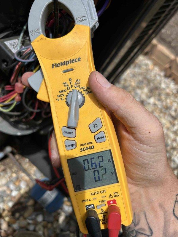 Responded to no cooling complaint on 15-20 year old dual fuel system blowing room temperature air. Upon arrival, performed diagnostic testing and confirmed supply air temperature at register measuring 58.2°F, indicating lack of cooling capacity. Utilized clamp meter to measure electrical current draw at outdoor unit, recording 0.52 amps, which is significantly below normal operating amperage for compressor operation. Low amperage reading suggests compressor failure, loss of refrigerant charge, or failed start components preventing compressor from running. Documented findings with thermal and electrical measurements for customer review and repair recommendations.