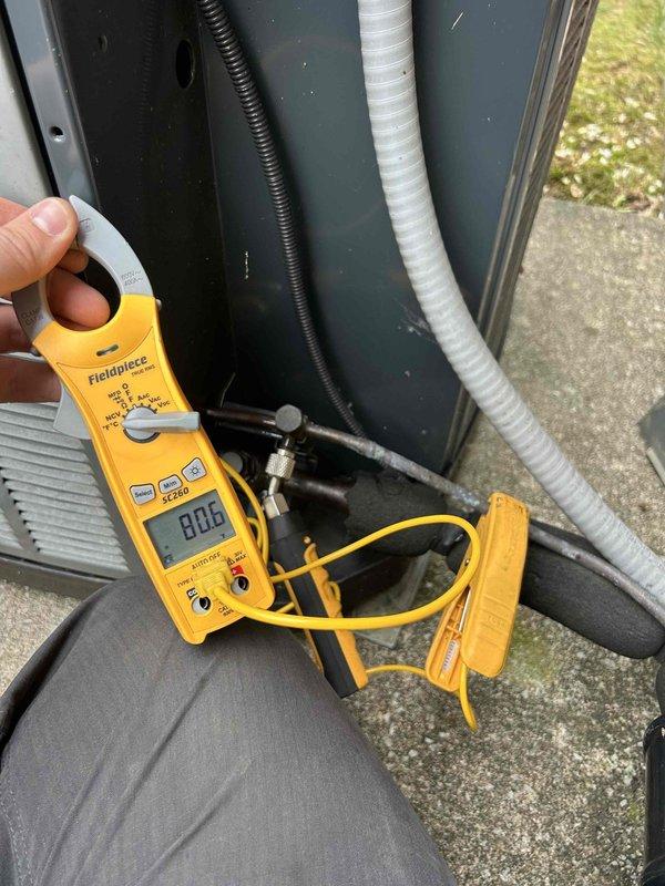 Responded to no cooling call on gas furnace with air conditioning system. Upon arrival, found thermostat set to 72°F with indoor temperature reading 81°F and system in OFF mode. Proceeded to outdoor condensing unit for diagnostic evaluation. Using Fieldpiece digital multimeter, measured electrical parameters at the outdoor unit to assess compressor and condenser operation. Checked voltage readings, which displayed 8.06 on meter, and inspected refrigerant line connections, copper piping, and electrical components. Verified proper power supply to unit and examined conduit connections and flexible hose routing. Performed standard diagnostic procedures to identify cause of cooling failure and determine necessary repairs to restore system to proper cooling operation.