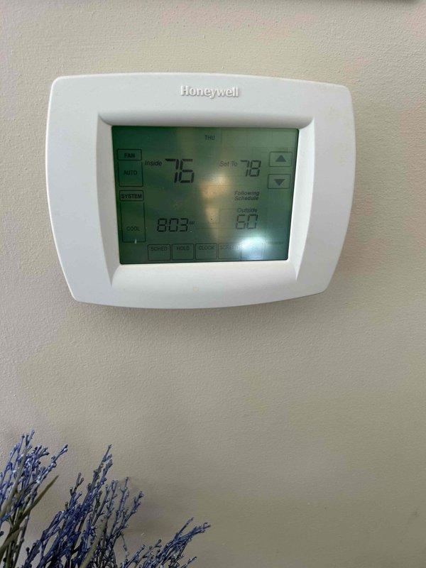Responded to no cooling call on American Standard Heritage 14 heat pump system (Model #4A6H4036B1000AA). Found outdoor unit compressor humming but condenser fan motor not operating. Diagnosed failed condenser fan motor with seized bearings - motor started temporarily after manual rotation but requires replacement. Measured capacitor at 6.1 microfarads, confirming capacitor is also weak and contributing to failure. Advised system over 10 years old with failed fan motor and weak capacitor requiring immediate replacement to restore cooling operation. Unit shut down at thermostat to prevent compressor damage from inadequate heat rejection.