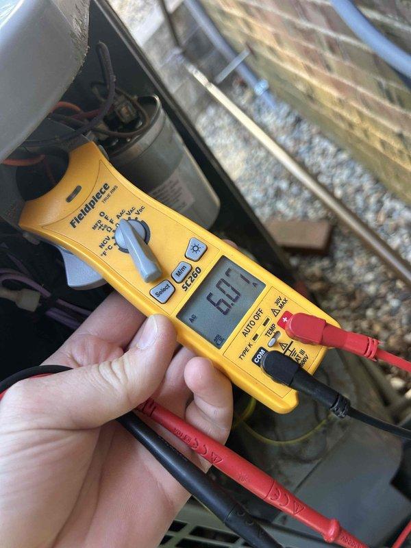 Responded to no cooling call on American Standard Heritage 14 heat pump system (Model #4A6H4036B1000AA). Found outdoor unit compressor humming but condenser fan motor not operating. Diagnosed failed condenser fan motor with seized bearings - motor started temporarily after manual rotation but requires replacement. Measured capacitor at 6.1 microfarads, confirming capacitor is also weak and contributing to failure. Advised system over 10 years old with failed fan motor and weak capacitor requiring immediate replacement to restore cooling operation. Unit shut down at thermostat to prevent compressor damage from inadequate heat rejection.