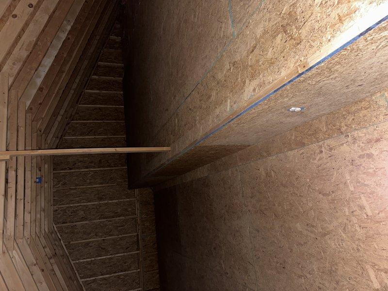 Conducted comprehensive site assessment for complete HVAC system replacement in pool house structure currently without existing equipment. Evaluated unfinished utility space with OSB wall construction and exposed framing to determine optimal placement for new indoor unit installation, documented existing conditions through detailed photography of installation area including structural supports and available mounting locations.