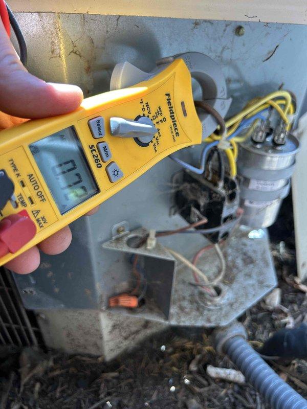 Responded to no cooling call on 11-year-old electric HVAC system affecting main floor unit. Upon arrival, found thermostat displaying 71°F while system was set to cool. Performed diagnostic testing of electrical components in outdoor condensing unit using digital multimeter. Measured voltage and amperage readings at capacitor and contactor assembly. Identified failed run capacitor reading 77.2 microfarads, significantly below manufacturer specifications. Replaced defective dual run capacitor with proper rated replacement. Cleaned electrical compartment of accumulated dust and debris. Verified proper voltage supply to compressor and condenser fan motor. Tested system operation through complete cooling cycle. Confirmed proper amperage draw on both compressor and fan motor. System restored to normal cooling operation with thermostat responding appropriately to temperature setpoint.