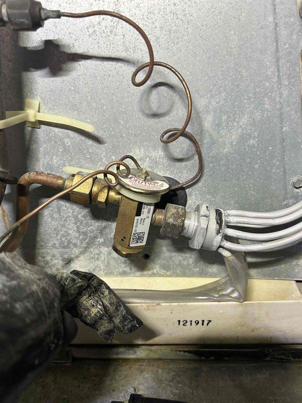 Returned to complete warranty work following a previous compressor replacement. Replaced failed indoor thermostatic expansion valve (TXV), recovered and reused existing refrigerant charge, and cleaned out the accumulator to restore proper system operation.