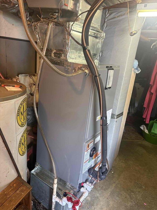 Completed full residential heat pump system installation including RUUD 3-ton 14.3 SEER2 heat pump (model RP14AY36AJ2NA), RUUD 3-ton multi-speed air handler (model RH2TY3617STANNJ), and 15kW electric heat kit (model RXBH-1724A15J-B). Installed outdoor unit on pad with snow legs, electrical disconnect box, and electrical whip kit; installed refrigerant line set with insulation and filter, connected with brass fittings and service ports. Indoor air handler mounted in basement with condensate drain trap, SS2 coil drain safety water sensor, transition to existing ductwork, and standard air filter rack. Installed digital programmable thermostat for system control. Removed and disposed of existing equipment, obtained applicable permits, and completed all electrical connections to code. System tested and operational upon completion.