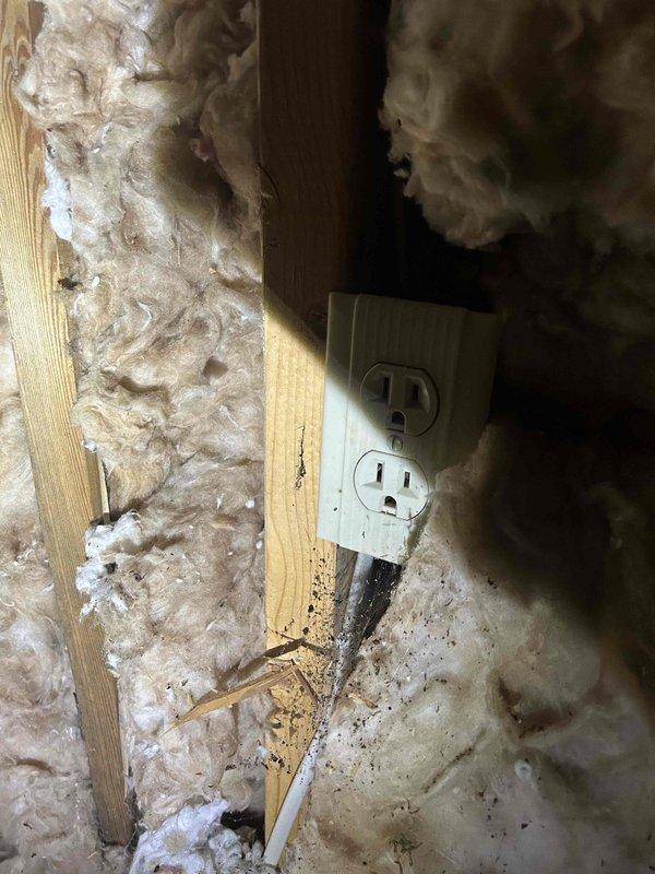 Conducted site assessment of small attic space to provide estimate for connecting or adding exhaust fan ventilation. Inspected existing electrical infrastructure, including wall-mounted outlets and wiring within exposed stud cavities with fiberglass insulation. Evaluated attic conditions including wooden joist structure, existing flexible metallic ductwork (approximately 6-8 inches diameter), and loose-fill insulation coverage. Documented current electrical access points and determined feasibility for exhaust fan installation and power supply routing through available wall cavities and attic space.
